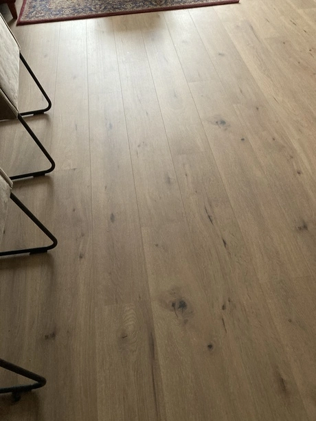 houten vloer met stoel en tapijt zichtbaar