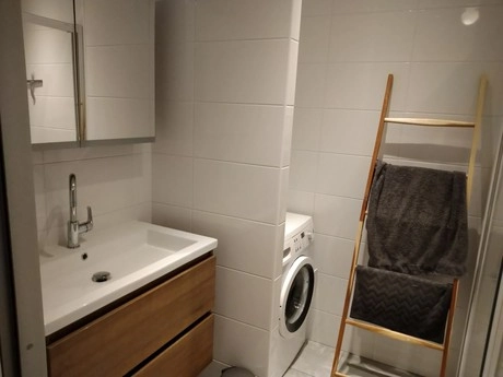 kleine badkamer met wastafel en wasmachine