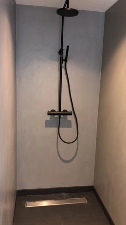 moderne douche met zwarte armatuur in badkamer