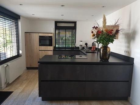 moderne keuken met donkere meubels en bloemen