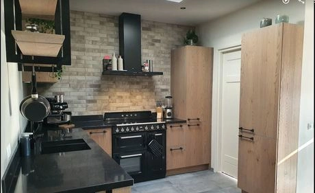 moderne keuken met houten kasten en zwarte apparatuur