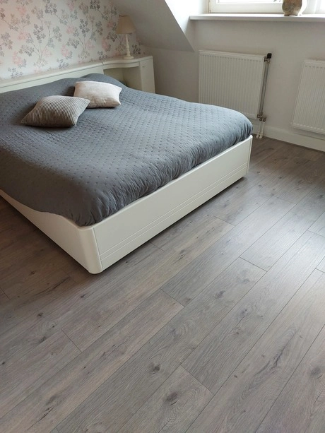 slaapkamer met een grijs dekbed en kussens