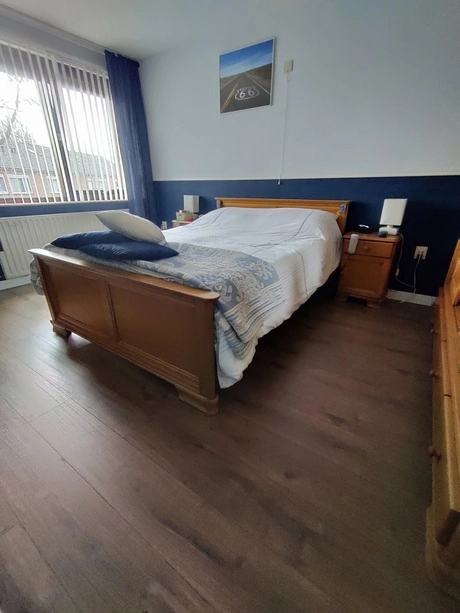slaapkamer met tweepersoonsbed en houten meubels