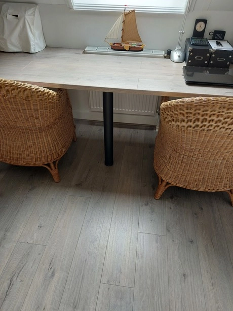 twee rotan stoelen bij een houten tafel