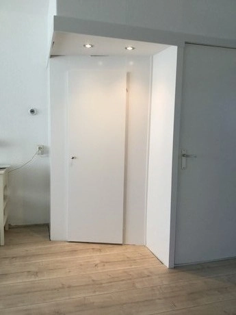 witte deur onder hoekige plafondverlichting geplaatst
