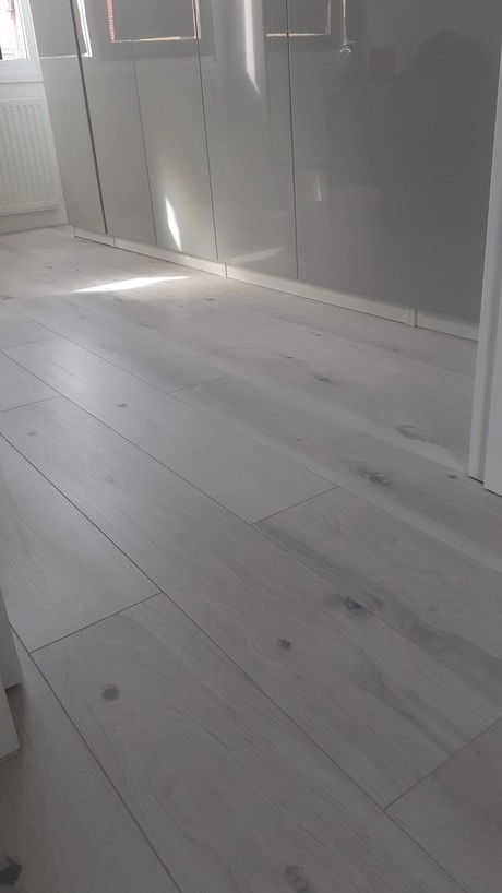 de kamer heeft een houten laminaatvloer