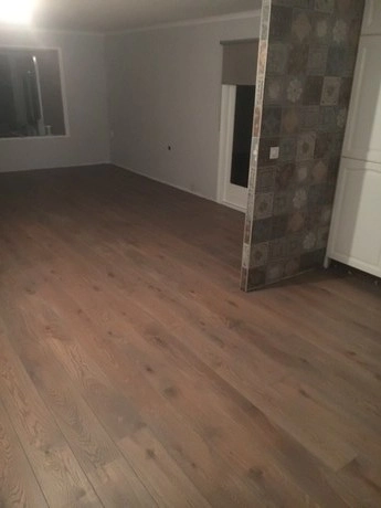lege kamer met houten vloer en tegelmuur