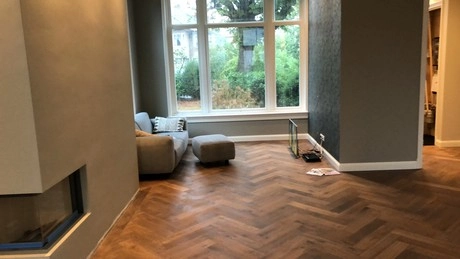 modern woonkamer met houten vloer en grote ramen