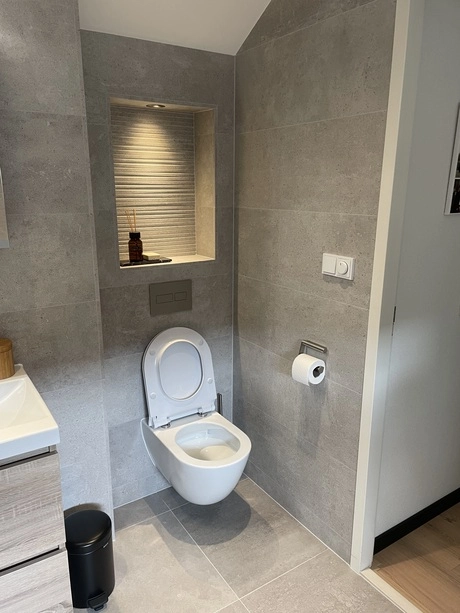moderne badkamer met zwevend toilet en inbouwplank