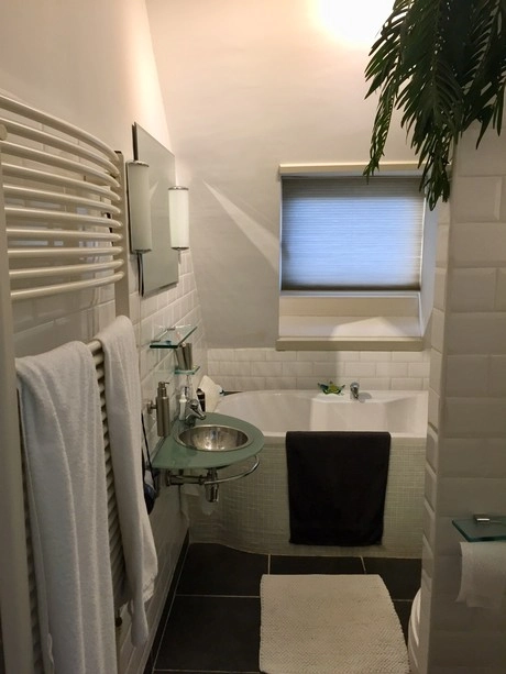 kleine badkamer met bad en wastafel