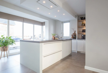 lichte moderne keuken met kookeiland en raam