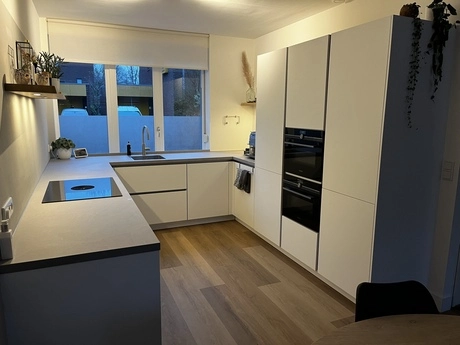 moderne keuken met witte kasten en apparaten