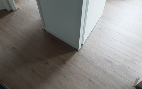 houten vloer bij een hoekkamer zonder meubels