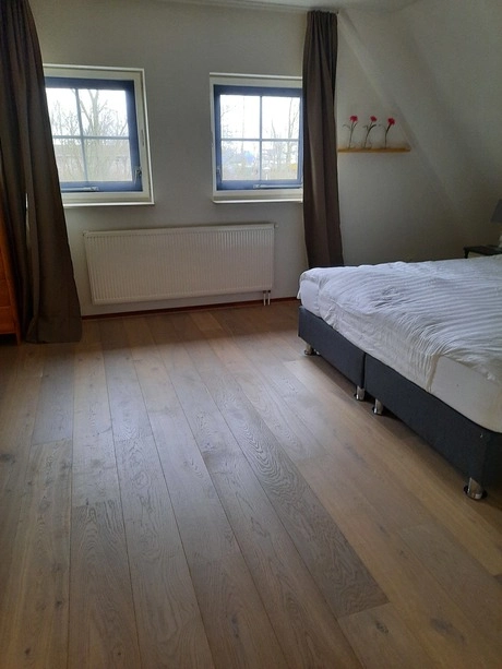 houten vloer in een lichte slaapkamer te zien