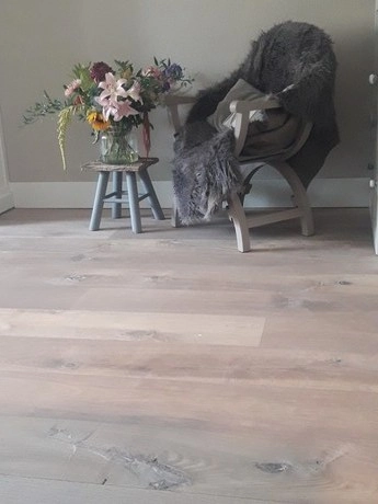 houten vloer met bloemen en stoel met deken