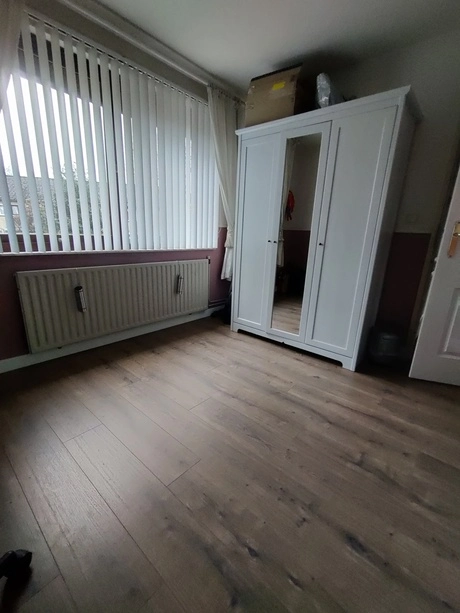 kamer met houten vloer en witte kast