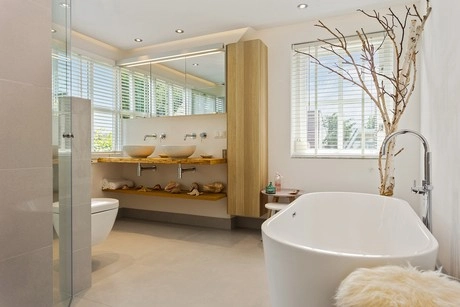 moderne badkamer met ligbad en natuuraccenten
