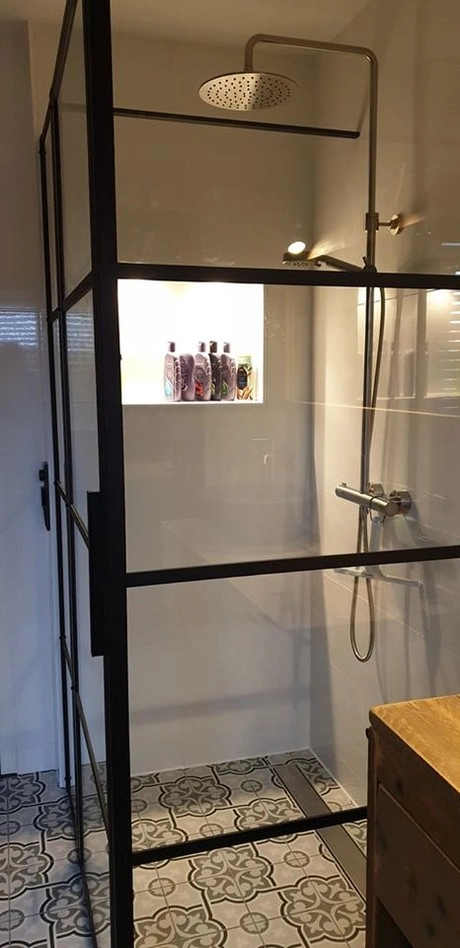 moderne douche met glazen wanden en shampoos
