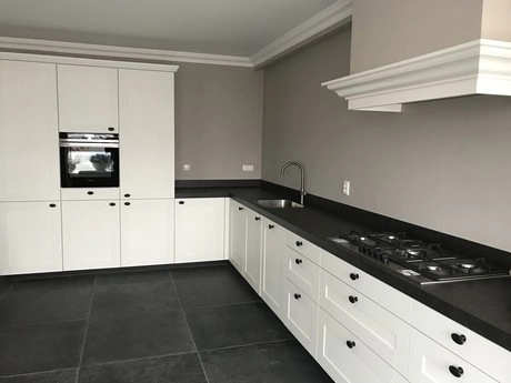moderne keuken met witte kasten en zwart aanrecht