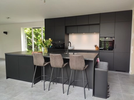 moderne keuken met zwart interieur en kookeiland