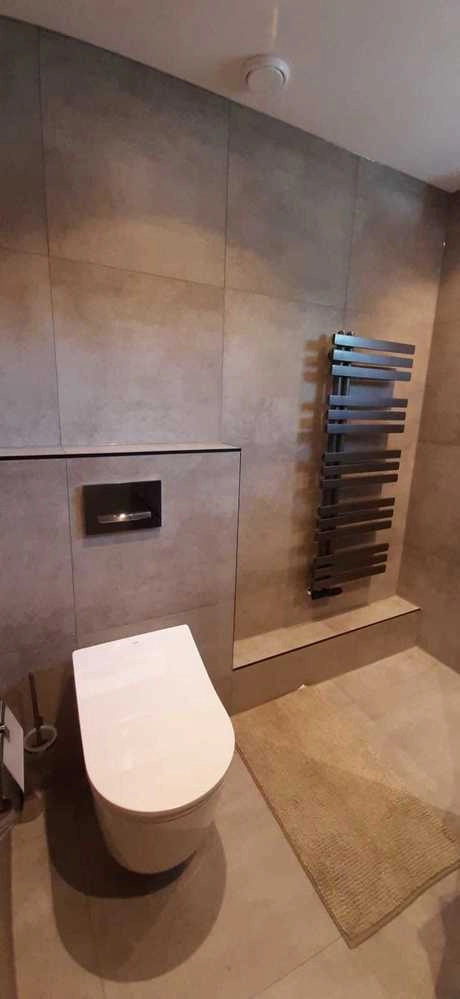 strakke badkamer met toilet en handdoekradiator