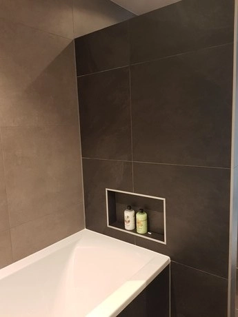 badkamer met strakke moderne tegels en bad