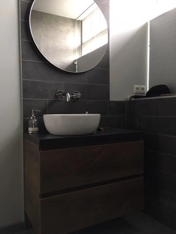 minimalistische badkamer met ronde spiegel en wastafel