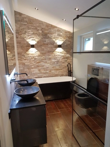 moderne badkamer met bakstenen muur en zwart sanitair