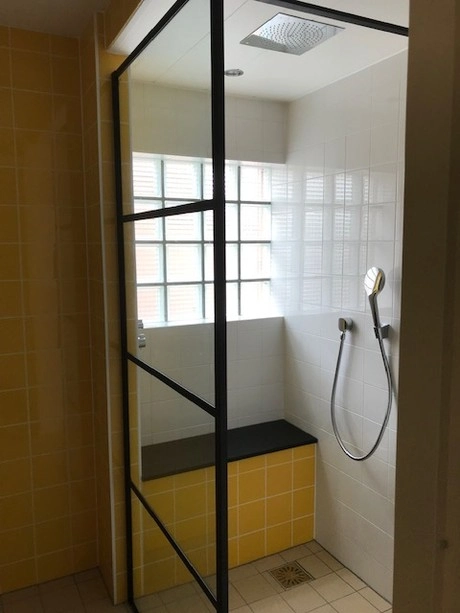 moderne douche met glazen wand en gele tegels