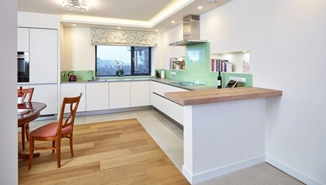 moderne keuken met houten vloer en groen glas