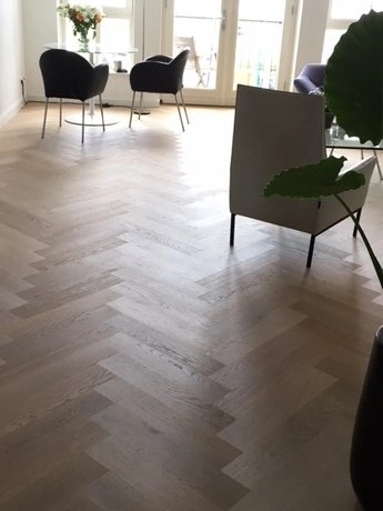 woonkamer met houten vloer en moderne meubels