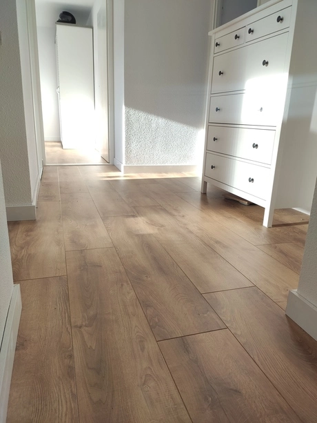 houten vloer en witte meubels in hal