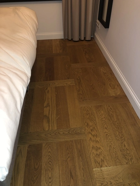 houten vloer in slaapkamer bij een bed