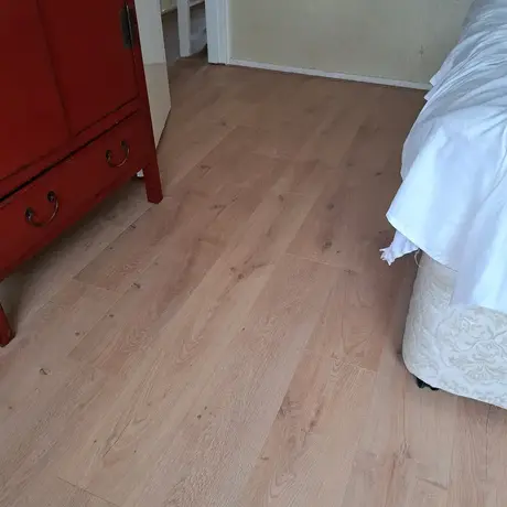 houten vloer naast een bed en kast