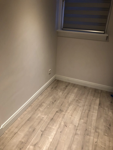 lege kamer met houten vloer en raam