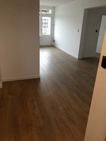 lege kamer met houten vloer en witte muren