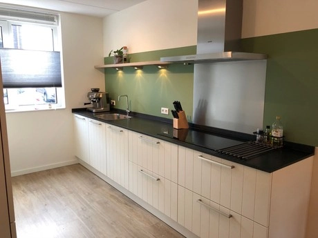 moderne keuken met groen accentmuur en apparatuur