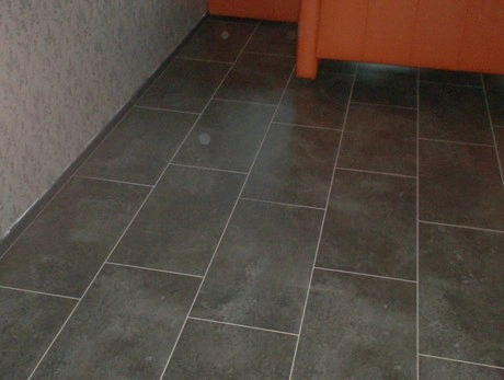 grijze tegelvloer naast een oranje muur
