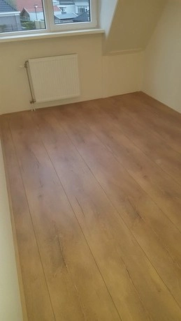 lege kamer met houten vloer en raam