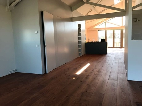lichte kamer met houten vloer en hoog plafond