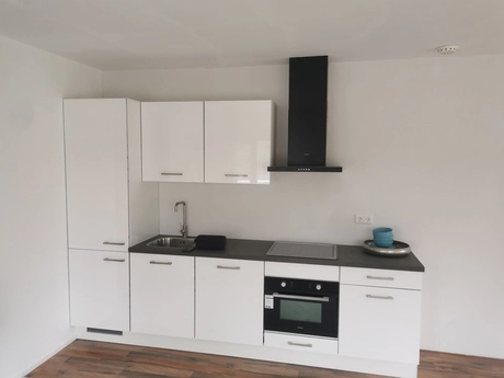 witte keuken met moderne apparatuur en spoelbak