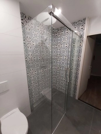 douche met glazen deuren en decoratieve tegels