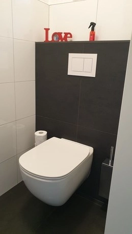 modern toilet met decoratief love bord bovenop plank