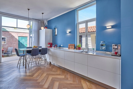 moderne keuken met blauwe muren en houten vloer